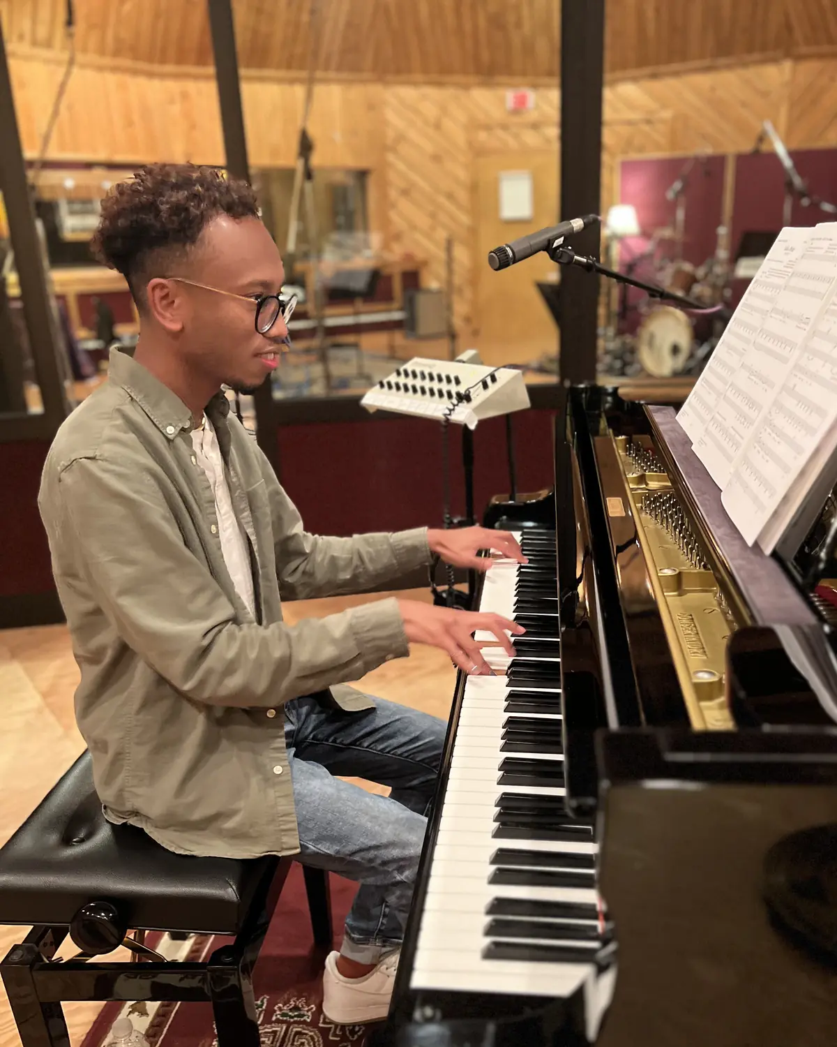 Patrick B. Phillips playing a grand piano in a recording studio